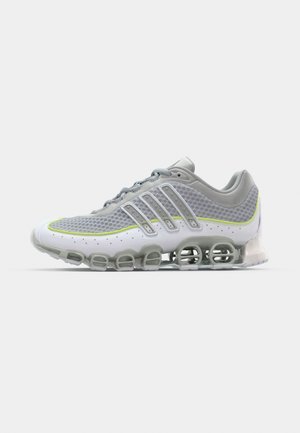 Athletic shoes with a breathable mesh upper, gray and white colors, rounded soles, and distinct shock-absorbing pods on the base.