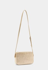 Geantă crossbody bej cu design cu logo embossat, textură netedă, formă rectangulară, curea ajustabilă și accente din metal auriu.