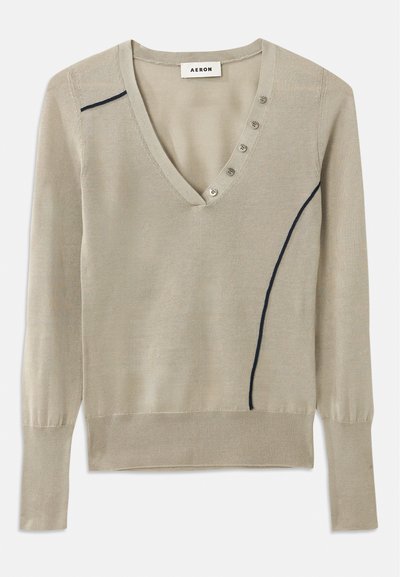 Svetr s výstrihom do V v svetlej béžovej pletenine, vybavený námorníckou akcentnou líniou a detailom s piatimi gombíkmi vpredu, s dlhými rukávmi a rebrovanými manžetami.