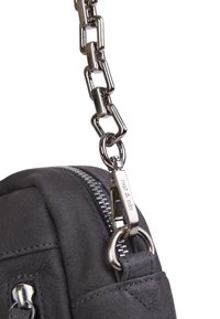 Bolso de cuero gris oscuro, con superficie texturizada, correa de metal, cremallera plateada y un detalle de logo. Diseño compacto con herrajes prominentes.