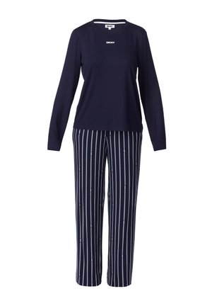 Top de manga larga azul marino con el logo de DKNY, combinado con pantalones rectos azules marino que tienen rayas verticales blancas y pequeños logos dispersos de DKNY.