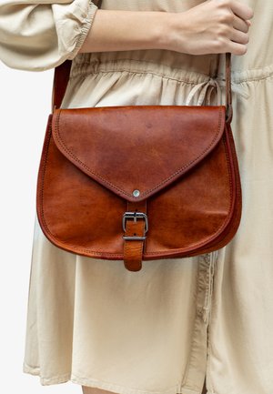Brown leather shoulder bag with flap closure, metal buckle, and smooth texture. Features stitched edges and a compact, rectangular shape.