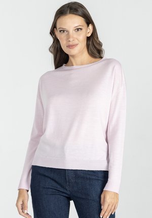 Jasnoróżowy sweter z długim rękawem, uszyty z miękkiego materiału, o luźnym kroju, z łódka dekoltem i ściągaczem u dołu, w połączeniu z ciemnoniebieskimi dżinsami.
