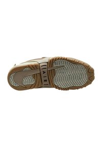 Sko sula med en beige mellansula med texturerade spår, en brun gummisula och en framträdande svart Nike-logotyp med "AIR" i vitt ovanför.