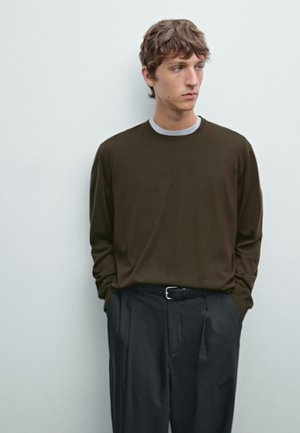 Brown long-sleeve shirt with a round neckline, layered over a gray inner shirt. Paired with dark trousers and a black belt. Smooth texture.