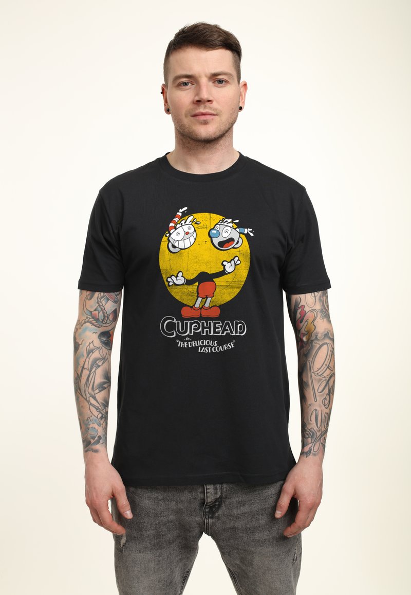 Schwarzes T-Shirt mit einem bunten Cuphead-Graphic und einem gelben Kreis-Hintergrund. Das Material wirkt weich; das Design umfasst Cartoon-Charaktere und Text.