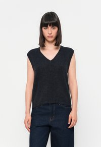Donkergrijze, mouwloze, V-hals gebreide trui van zacht materiaal. Casual fit met een soepele textuur, gedragen met donkerblauwe jeans.