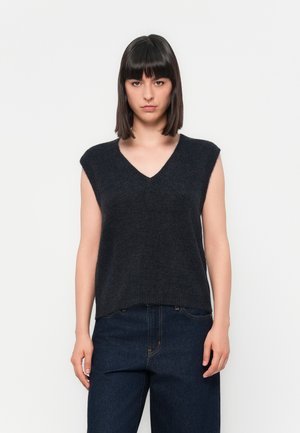 Mørkegrå, ermeløs, V-hals strikkegenser laget av mykt materiale. Casual passform med en jevn tekstur, brukt sammen med mørkeblå jeans.