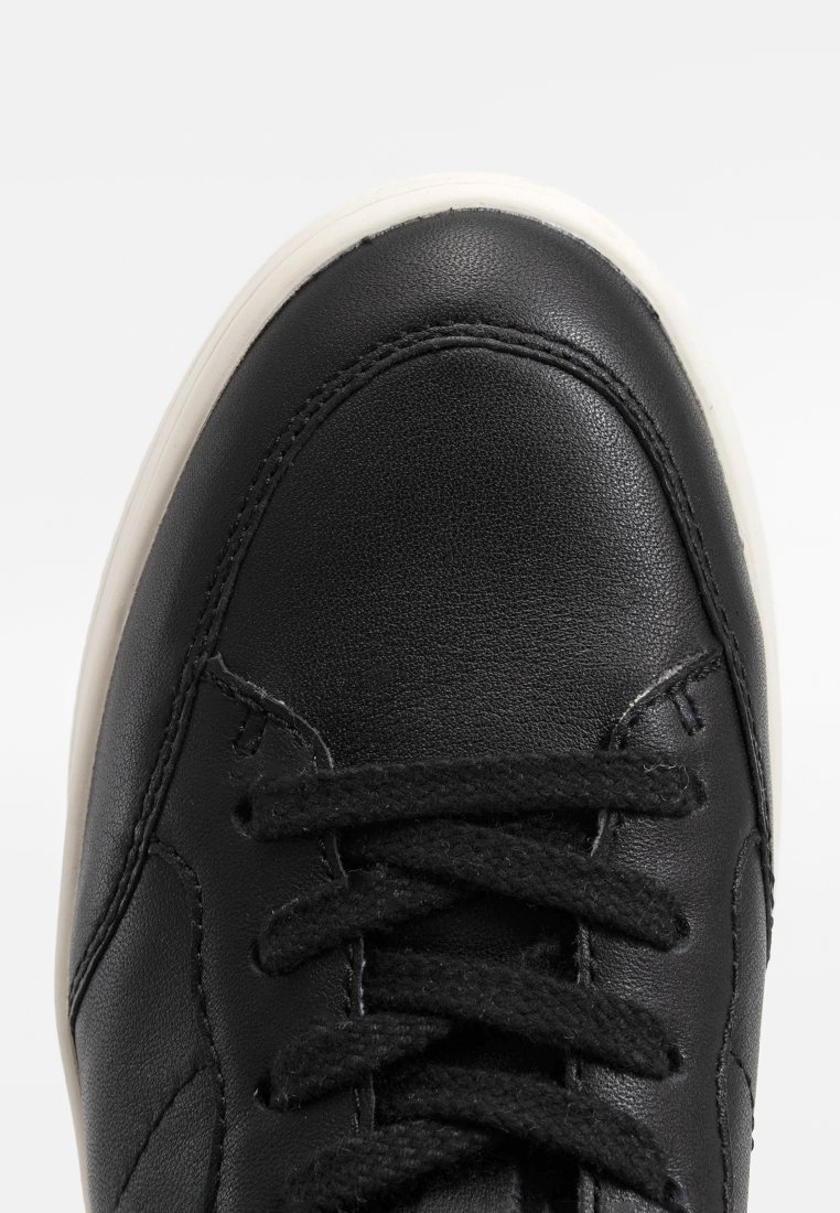 Schwarze Ledersneaker mit runder Zehenkappe, ausgestattet mit schwarzen Schnürsenkeln, einer weißen Gummisohle und dezenten Nähdetails. Glatte Textur.