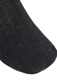 Calzino nero in maglia con una texture a coste, dettagli luccicanti e un po' di pelucchi sulla superficie. La zona della punta è arrotondata e liscia.