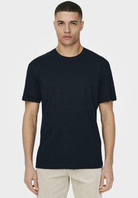 Navyblaues Kurzarm-T-Shirt aus Baumwolle; mit Rundhalsausschnitt und normaler Passform, vor einem schlichten weißen Hintergrund präsentiert.