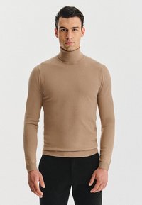 Beżowy sweter typu golf w dopasowanym fasonie, wykonany z miękkiej, gładkiej tkaniny z prążkowanymi akcentami wokół dekoltu i mankietów.