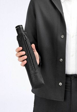 Crni držač za kišobran od teksturirane tkanine, sa zatvaračem na zip, iz kojeg proviruje glatki crni kišobran.