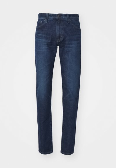 Temno modri kavbojasti hlače z ravno nogo, ki imajo klasično gumbno zapiranje in sprednje žepe. Gladka tekstura, minimalno zbledelost.