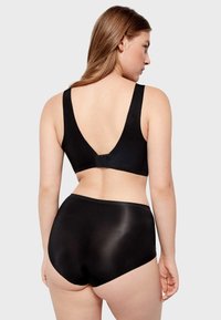Zwarte beha met een diepe V-rug en brede bandjes, gecombineerd met hoge zwarte onderbroek. Dure textuur, eenvoudig ontwerp en geen zichtbare patronen.