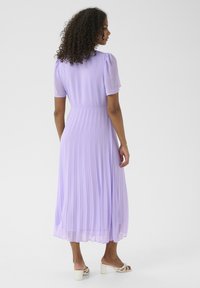 Rochie din lavandă cu pliuri, cu mâneci scurte tip puff, talie strânsă și fustă vaporoasă, realizată dintr-un material ușor. Textură fină, lungime până la gleznă.