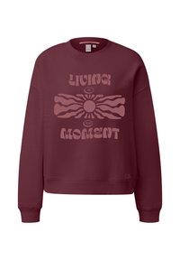 Sweatshirt bordeaux avec des poignets et un ourlet côtelés. Présente un grand motif rose clair avec le texte "VIVRE L'INSTANT" et un design de soleil.