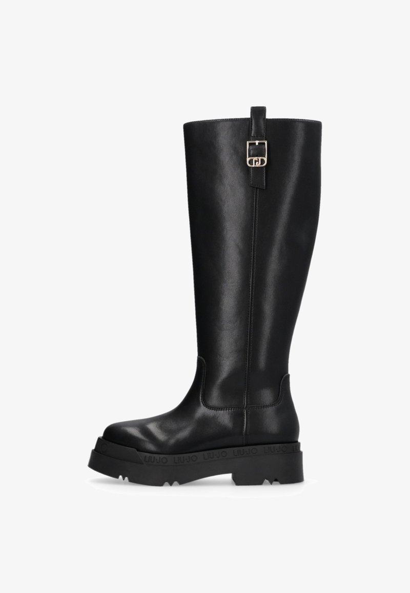 Botte noire en cuir, montant jusqu’au genou, avec semelle épaisse, boucle décorative sur la tige supérieure et détails de surpiqûre discrets.