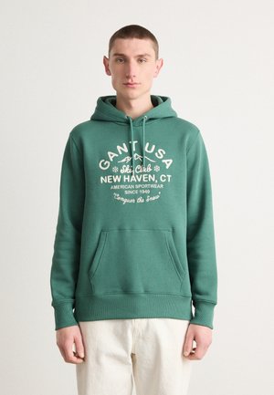 Green hoodie made of cotton blend, featuring a front pocket, drawstring hood, and a white graphic print with winter-themed text.