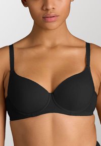 Sostenitore nero modellato con spalline sottili e design senza cuciture. Realizzato in tessuto morbido, presenta una costruzione semplice e nessun abbellimento visibile.
