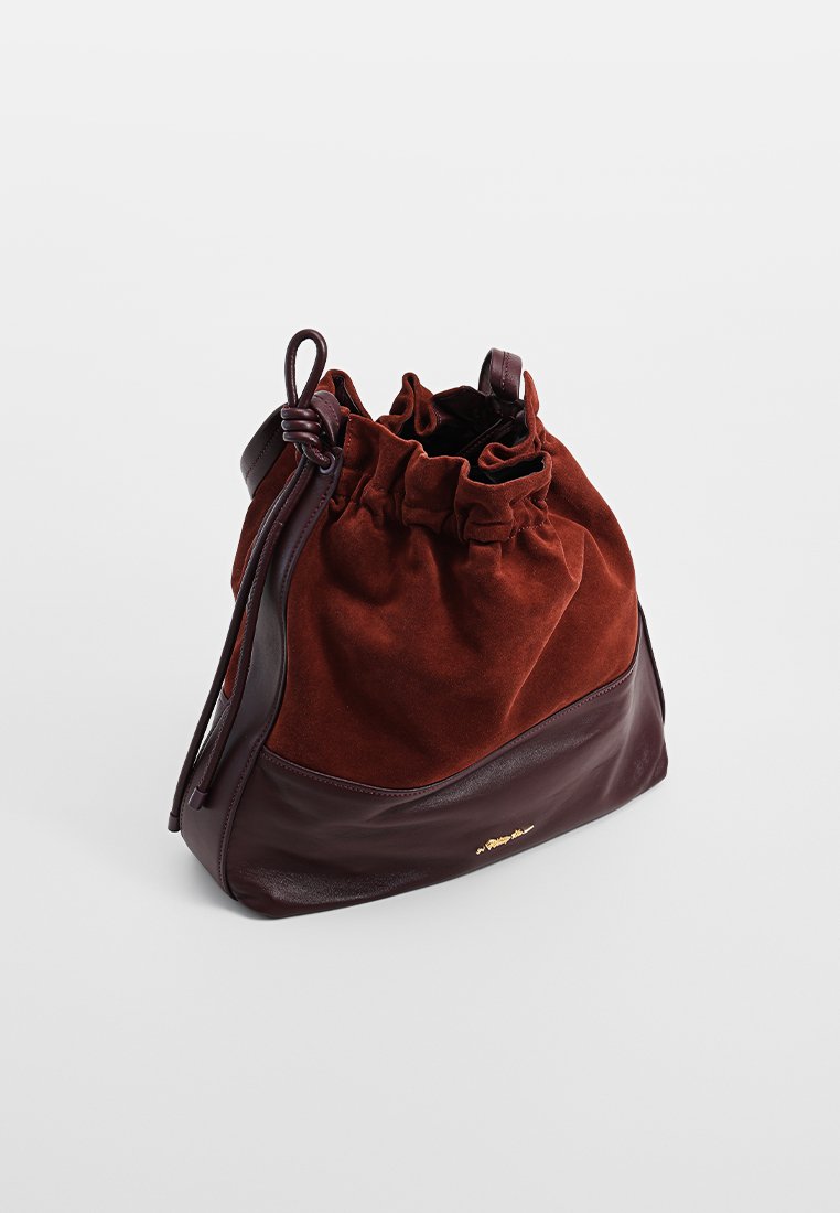 Brązowa zamszowa i skórzana torebka w formie worka z ściągaczem, z zebranym szczytem i małym złotym logo z przodu.