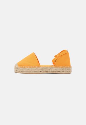 Espadrille en toile orange avec un bout pointu, semelle en jute tissée et sangle ajustable à la cheville. Texture lisse avec des détails de couture subtils.