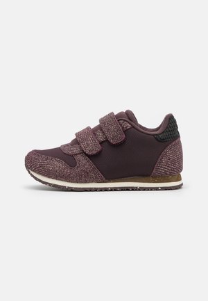 Purple athletic shoe with two Velcro straps, textured fabric, and a contrasting black heel accent. Features a rubber sole with grip.