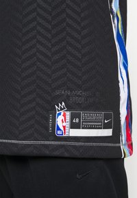 Black mesh basketball jersey with herringbone pattern. Features colorful side accents, NBA logo, and Nike branding. Size 48 label included.