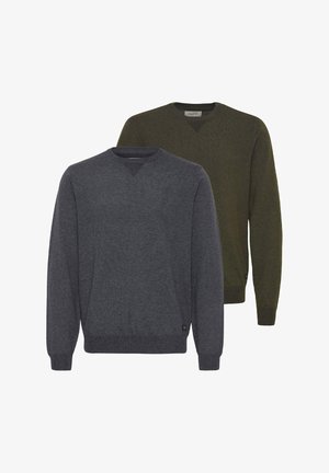 Pull long à manches longues vert foncé avec un col rond côtelé, porté avec un pantalon slim noir et des baskets grises avec des rayures blanches.
