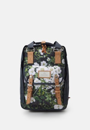 Zwart rugtas met een bloemenpatroon in wit en groen. Bruine leren banden en accenten. Heeft een bovenste trekkoordsluiting en een logo-patch.