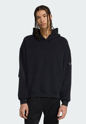 Sort hætte sweatshirt med afslappet pasform, der har manchetter og en kant, lavet af blødt materiale. Indeholder en diskret design detalje på ærmet.