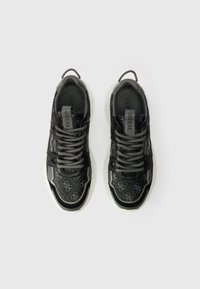 Černé tenisky vyrobené z umělého materiálu s vzorovaným svrškem, šedými tkaničkami a bílou gumovou podrážkou. Obsahují akcenty s logem a texturované detaily.