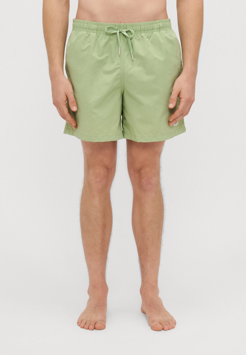 Heledad roheline ujumispüksid kergest kangast. Omavad elastset vööd koos paelaga, külgiseid taskuid ja lihtsat disaini.