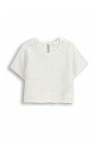 Biały, teksturowany krótki top z okrągłym dekoltem i zapięciem na guziczek z tyłu. Materiał ma delikatny połysk.