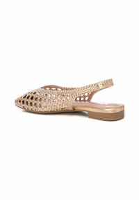 Zapato tipo slingback en estilo de celosía de color oro rosado metálico, con punta afilada y tacón bajo y grueso. Material texturizado tejido en todo el zapato.