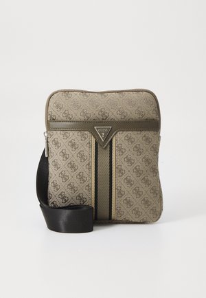 Väskan i tanfärgad mönster har en svart justerbar rem, en triangulär logotyp och mörka ränder ner i mitten på framsidan.