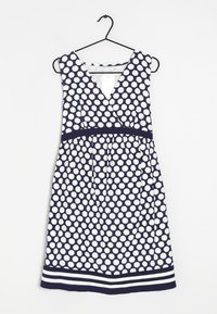 Vestido de lunares en azul marino y blanco con escote en V y forma en A. Cuenta con una cintura ajustada y un detalle de dobladillo a rayas. Fabricado con tela ligera.