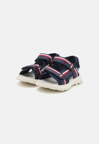 Navy children's sandals with adjustable straps, red and white accents, breathable mesh upper, and a cushioned white sole.