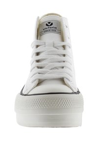 Bottines blanches en cuir avec une semelle en caoutchouc texturé, dotées de lacets plats, d'un bout rond et d'une étiquette de logo sur la languette.