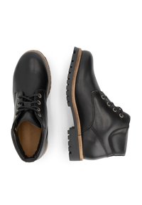 Een paar zwarte leren enkellaarzen met vetersluiting en bruin gestikte zolen, getoond vanuit boven- en zijaanzicht.