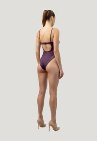 Costume da bagno intero viola con schiena bassa e spalline regolabili, caratterizzato da un design a gamba alta e finitura liscia e opaca.