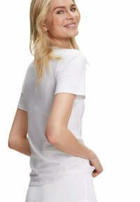 Weißes T-Shirt mit kurzen Ärmeln, aus weichem Stoff, körpernaher Schnitt, runder Ausschnitt und glatte Textur, getragen mit weißen Hosen.