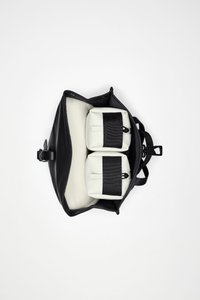 Sort lædertaske med gråt indvendigt rum, som indeholder to hvide poser sikret med sorte stropper. Tasken har en struktureret, rektangulær form.