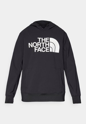 Svart hettegenser laget av mykt stoff med en stor hvit logo på forsiden. Den har snøring i hetten og en romslig kengurulomme.