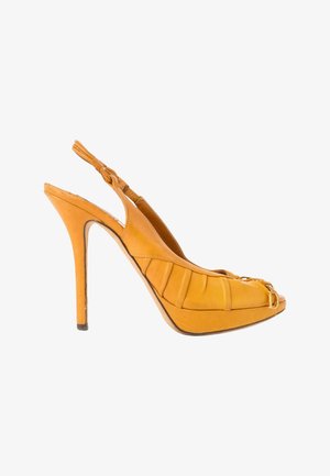 Zapato slingback de tacón alto de cuero amarillo con suela de plataforma, diseño plisado en el lateral y una pequeña hebilla dorada en la parte delantera.