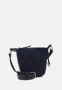 Sac bandoulière en suede bleu marine avec une texture douce, dotée d'une base plate, d'une sangle en cuir ajustable et de détails en métal.
