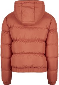 Polstret hettejakke i rust oransje, med en quiltet design, strikkede mansjetter og en ribbestrikket nederkant for en tettsittende passform. Glatt tekstur.