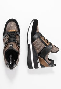 Höga sneakers med ett brunt vävt tyg, svarta läderdetaljer, metalliska inslag och en tjock vit sula. Strukturerad och stilren design.