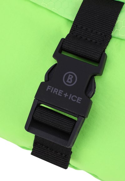 Tessuto verde brillante con una fibbia in plastica nera con testo "FIRE+ICE", attaccata a una cintura. Motivo esagonale testurizzato visibile sulla parte superiore.