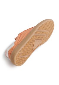 Suela de zapato con parte superior de cuero naranja y blanco, suela de goma texturada, y patrón de espiga. Presenta tachuelas decorativas a lo largo del talón.